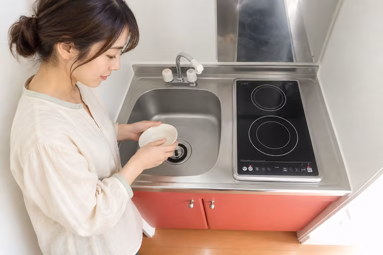 コンパクトなキッチンで、食器を手にする女性の横顔
