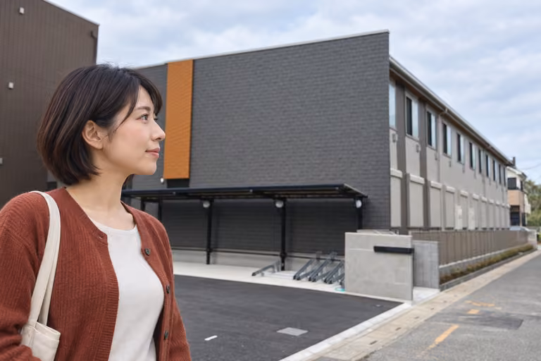 実際の建物の入口付近を確かめる女性の横顔