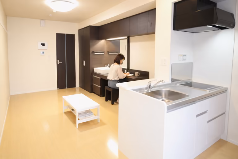 室内奥の備え付けカウンターでノートに書き込む女性